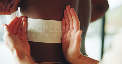 Buy stock photo Hands, physiotherapy and patch on back for injury, recovery and rehabilitation at clinic. Person, chiropractor and service for patient with pain, muscle ache or tape for wellness with inflammation