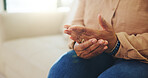 Home, person and hands with pain, arthritis and massage for injury relief with medical health risk. Fingers, sore joint and woman with fibromyalgia, osteoporosis or inflammation in living room