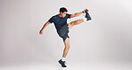 Fitness, kick and stretching with man on studio space for start of training or workout routine. Exercise, legs and warm up with athlete on gray background mockup for challenge or sports performance