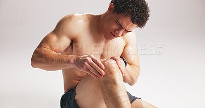 Buy stock photo Man, massage or knee pain in studio from workout challenge, difficult exercise or training accident. Athlete, person or hurt leg with joint inflammation, sports injury or problem on white background.
