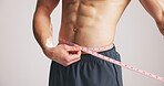 Strong, man or abdomen in studio with tape measure for weight loss, exercise results or progress. Fitness, person or check size of waist for bodybuilding, wellness or muscle goal on white background.