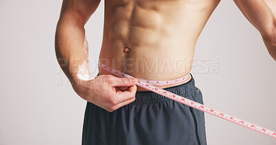 Buy stock photo Strong, man or abdomen in studio with tape measure for weight loss, exercise results or progress. Fitness, person body or check size of waist for six pack, wellness or muscle goal on white background