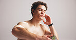 Fitness, earphones and man in studio with mobile for audio, online playlist or streaming radio. Exercise, music and shirtless person with phone to listen to sound, relax or song on white background