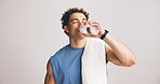 Man, fitness and drinking water with towel in studio for hydration on a white background. Active, male person or model with mineral liquid, aqua or beverage for workout break, recovery or rest