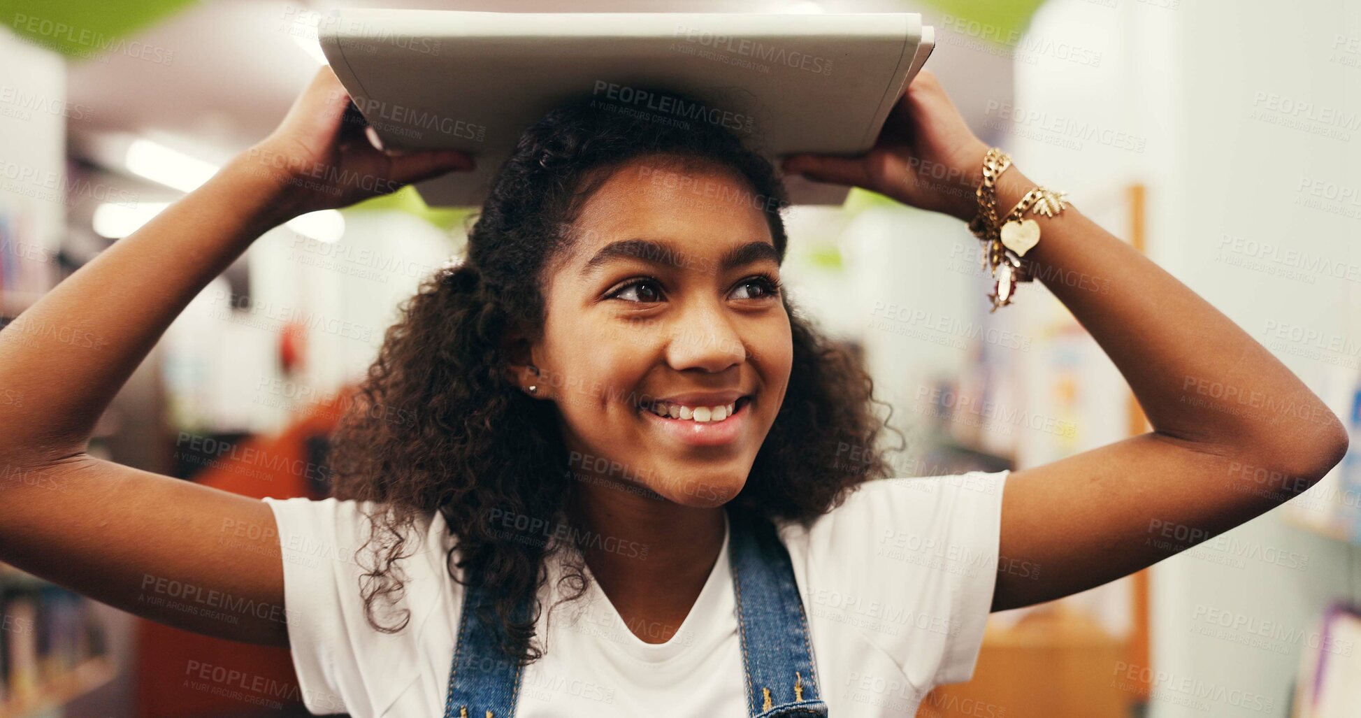 Buy stock photo Happy girl, student and education with book in library for study, learning or academic journey. Child, kid or learner with smile, story or novel for reading, knowledge or wisdom for youth development