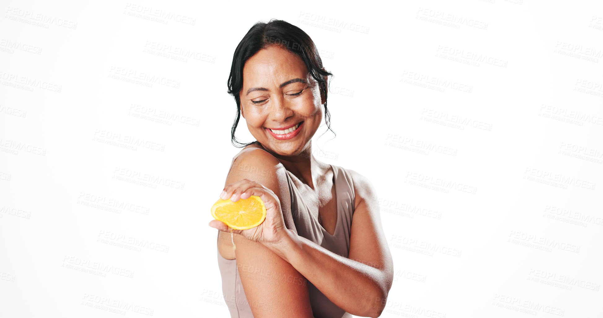 Buy stock photo Squeeze, beauty and woman with orange in studio for natural, organic or skincare cosmetics. Happy, vitamin c and mature female person with citrus fruit for antiaging dermatology by white background.