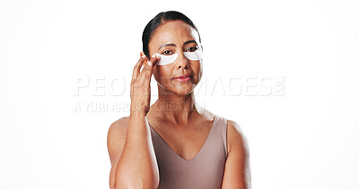 Buy stock photo Eye pads, portrait and mature woman in studio for dark circles, circulation and skincare. Mockup space, dermatology and person with beauty mask for wellness, hydration and health on white background