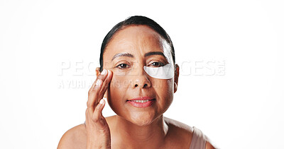 Buy stock photo Eye mask, beauty and portrait of mature woman in studio for dark circles, circulation or skincare. Mockup space, dermatology and person with pads for wellness, hydration or health on white background