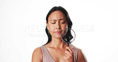 Buy stock photo Magnifying glass, beauty and mature woman in studio for skincare inspection, self care results and lens tool. Dermatology investigation, anti aging focus and glow with person on white background