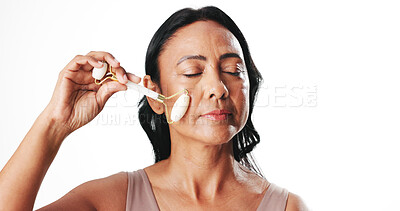 Buy stock photo Face roller, beauty and woman in studio, wellness and dermatology on white background. Mockup space, cosmetic product or mature person with treatment, routine and skincare with tools and healthy skin