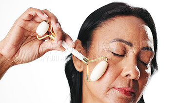 Buy stock photo Face roller, cosmetics and woman in studio, beauty and dermatology on white background. Mockup space, skincare product or mature person with treatment, blood circulation or wellness with healthy skin