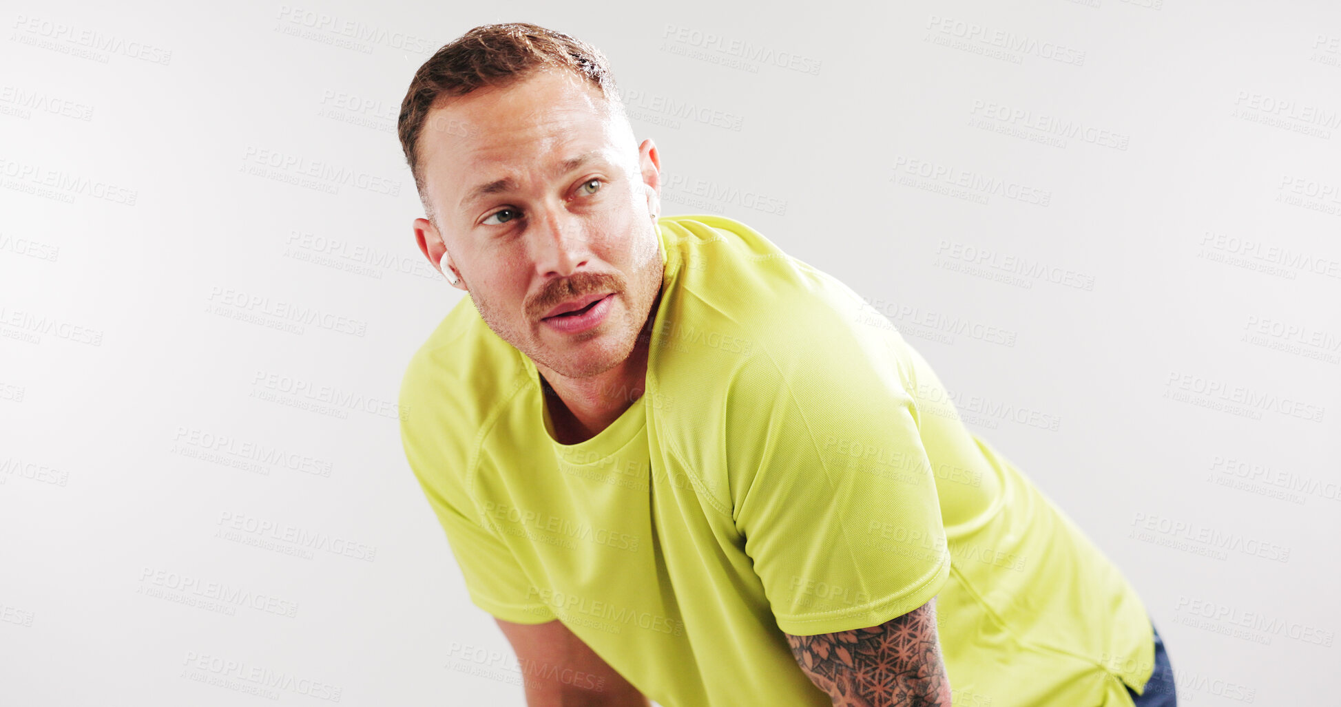 Buy stock photo Tired, exercise and man in studio thinking for recovery from fitness, training and listen to music. Mockup space, earphones and person with sweat, fatigue and idea for health on white background
