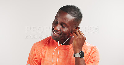 Buy stock photo Black man, earphones and happy for fitness in studio, streaming and mockup space on white background. African person, smile and listen to music with audio subscription, exercise or training routine