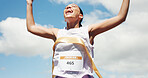 Woman, marathon and celebration with ribbon at finish line with low angle, goals and winning performance. Person, champion and happy runner with achievement, success and shout for sports milestone