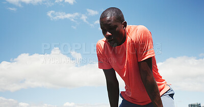 Buy stock photo Tired, runner and black man in city for rest, recovery and break for exercise, workout and training. Sports, blue sky and person with fatigue, sweat or health in town for fitness, wellness or running