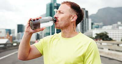 Buy stock photo Man, fitness and drinking with water bottle in city for workout break, rest or recovery. Active, male person or runner with mineral liquid, aqua or beverage for sports hydration in an urban town