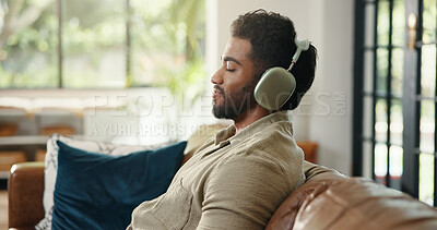 Buy stock photo Headphones, relax and man on sofa in home listening to music, playlist or radio in living room. Happy, audio tech and male person streaming song, album or podcast for chilling on weekend in house.