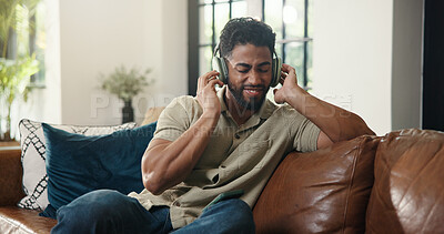 Buy stock photo Headphones, happy and man on sofa in home listening to music, playlist or radio in living room. Relax, audio tech and male person streaming song, album or podcast for chilling on weekend in house.