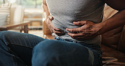 Buy stock photo Hands, ibs and tummy with man on sofa in living room of home for indigestion symptoms closeup. Abdomen, pain and stomach ache with person in apartment for chronic digestive or gastro condition