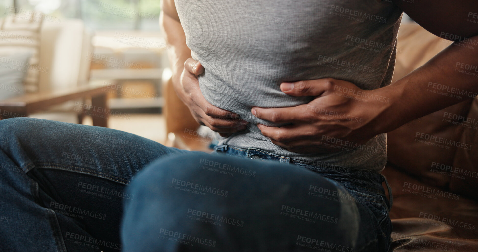 Buy stock photo Hands, ibs and tummy with man on sofa in living room of home for indigestion symptoms closeup. Abdomen, pain and stomach ache with person in apartment for chronic digestive or gastro condition