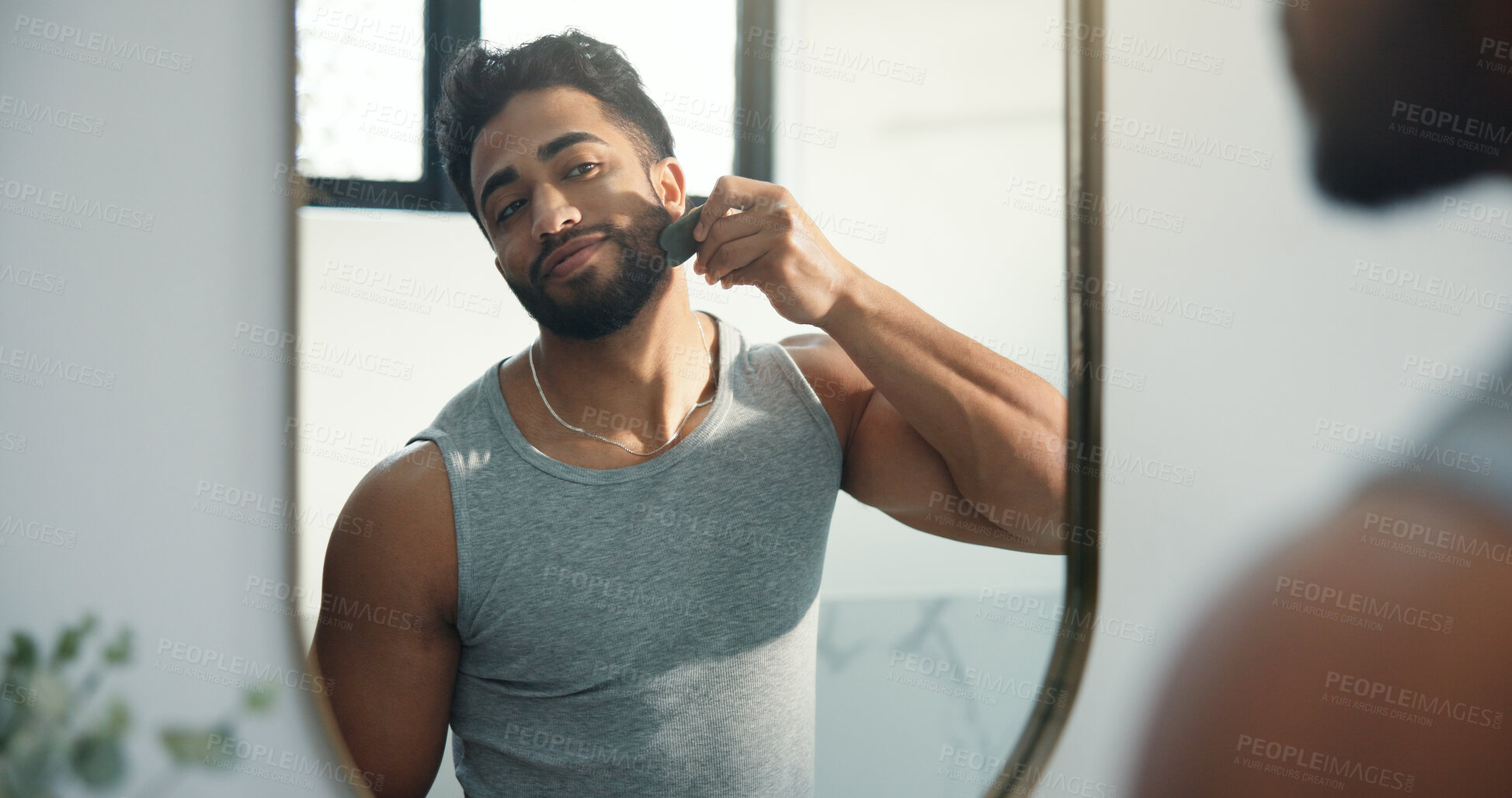 Buy stock photo Mirror, man and gua sha for skincare in bathroom, facial beauty or lymphatic drainage. Massage, happy person and jade stone for healthy skin, natural dermatology and self care with reflection in home