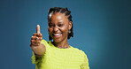 Happy, black woman and portrait with thumbs up in studio for good job on a blue background. Female person, model or smile with like emoji, yes sign or OK for well done, thank you or feedback on space