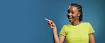 Portrait, pointing and African woman with smile in studio, show announcement or advertising with confidence. Banner, mockup space and person with hand gesture for promotion, happy or blue background