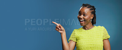 Buy stock photo Portrait, pointing and African woman with smile in studio, show announcement or advertising with confidence. Banner, mockup space and person with hand gesture for promotion, happy or blue background