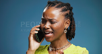 Buy stock photo Black woman, argument and stress with phone call in studio for disagreement on a blue background. Frustrated, female person or model shouting with mobile smartphone for fight, dispute or issue