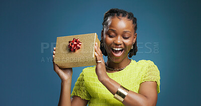 Buy stock photo Box, decoration and smile with black woman in studio for celebration or surprise present. Energy, gift and package with excited African person isolated on blue background for Christmas giveaway
