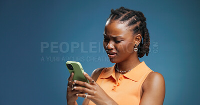 Buy stock photo Confused, phone and text message with black woman in studio for fraud or phishing scam reaction. App, doubt and typing with African person on blue background for contact or fake news notification