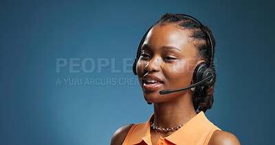 Buy stock photo Happy, black woman and consultant with headset in studio for communication on a blue background. Female person, agent or model with mic for virtual assistance, help or call center support on space
