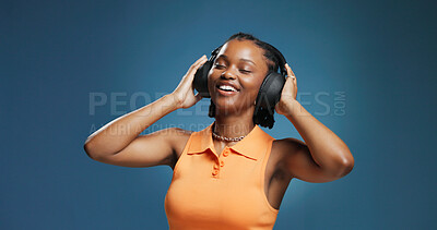 Buy stock photo Headphones, smile and black woman in studio for dance, listening and music playlist. Happy, audio tech and African female person with groove for album, radio or song for rhythm on blue background