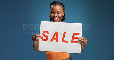Buy stock photo Happy, black woman or sign with sale for advertising or marketing on a blue studio background. Female person, promoter or model with poster, billboard or text for shopping deal, discount or low price