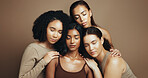 Women, eyes closed and diversity in studio for beauty, solidarity and bonding together with hug or unity. Friends, support and inclusion on brown background for love, community or natural dermatology