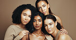 Women, portrait and hug in studio for dermatology, solidarity and bonding together with diversity and unity. Friends, support and inclusion on brown background for love, community and natural beauty