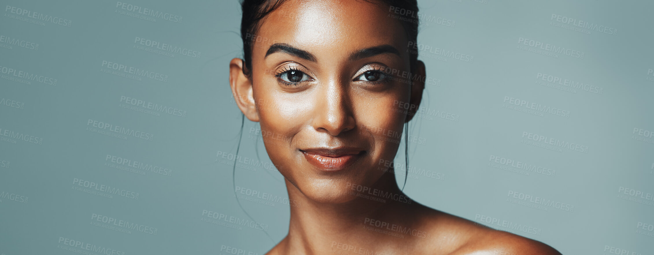 Buy stock photo Portrait, skincare and woman with glow in studio, natural beauty or dermatology. Face, shine and happy Indian model with cosmetics for aesthetic, health or banner on gray background with mockup space