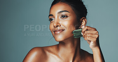 Buy stock photo Skincare, beauty and happy woman with gua sha, facial circulation or reduce inflammation for wellness. Dermatology tool, healthy glow and person sculpt with jade crystal, space or studio background
