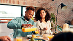 Happy couple, family and juice with food for dining, meal or gathering together at dinner table. Man, woman or pouring with orange drink or smile for vitamin C, thanksgiving or serving in house