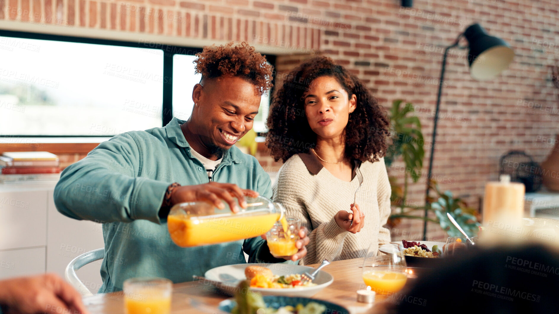 Buy stock photo Happy couple, family and juice with food for dining, meal or gathering together at dinner table. Man, woman or pouring with orange drink or smile for vitamin C, thanksgiving or serving in house
