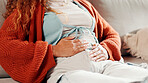 Hands, menstruation and woman on sofa with massage, PMS discomfort and stomach ache in symptoms. Health, cramps and girl in house with belly rub, endometriosis and soothe abdominal pain on cycle.