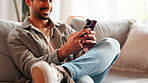 Hands, phone and man relax in home for online dating, social media profile and post. Mobile, smile and person in living room for communication with contact, typing text and response on internet
