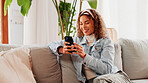 Smile, smartphone and woman in home on sofa for blog post, social media profile and news. Mobile, relax and African person in living room for communication with contact, typing text or online chat