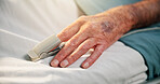Hands, sick and old person with oximeter in hospital bed to monitor pulse, blood levels and post surgery. Closeup, elderly patient or medical device to track oxygen, chronic condition and operation
