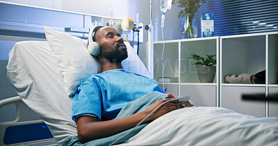 Buy stock photo Black man, relax and sleep with headphones in hospital bed for streaming music, podcast and recovery. Male person, inpatient and listening to audio of playlist, album and healing nap from operation