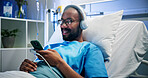 Black man, headphones and relax with phone in hospital bed for streaming music, ebook and recovery. Male person, inpatient and digital for listening to playlist, album audio and healing of operation