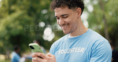 Buy stock photo Phone, typing and volunteer with man in park for charity, community outreach or food drive. App, smile and text message with happy person outdoor for activism, donation or non profit communication