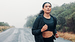 Outdoor, fitness and athlete running on road, marathon training or practice for long distance competition. Morning mist, resilience challenge and woman with endurance workout, cardio and performance 