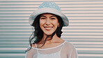 Portrait, smile and woman in city for travel, vacation or urban adventure by garage door. Hat, happiness and person outdoor with confidence on holiday, tourism or space on trip with wind in Argentina