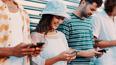 Buy stock photo Phone, smile and typing with friends outdoor together for connection or social media browsing. App, contact and text message with group of happy people in line for chatting online or communication